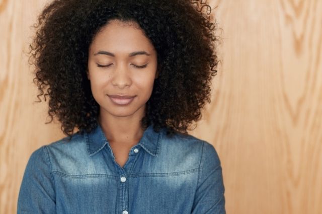 Fear of the blank page met with calm, shown by a peaceful woman with eyes closed, centering herself before beginning.