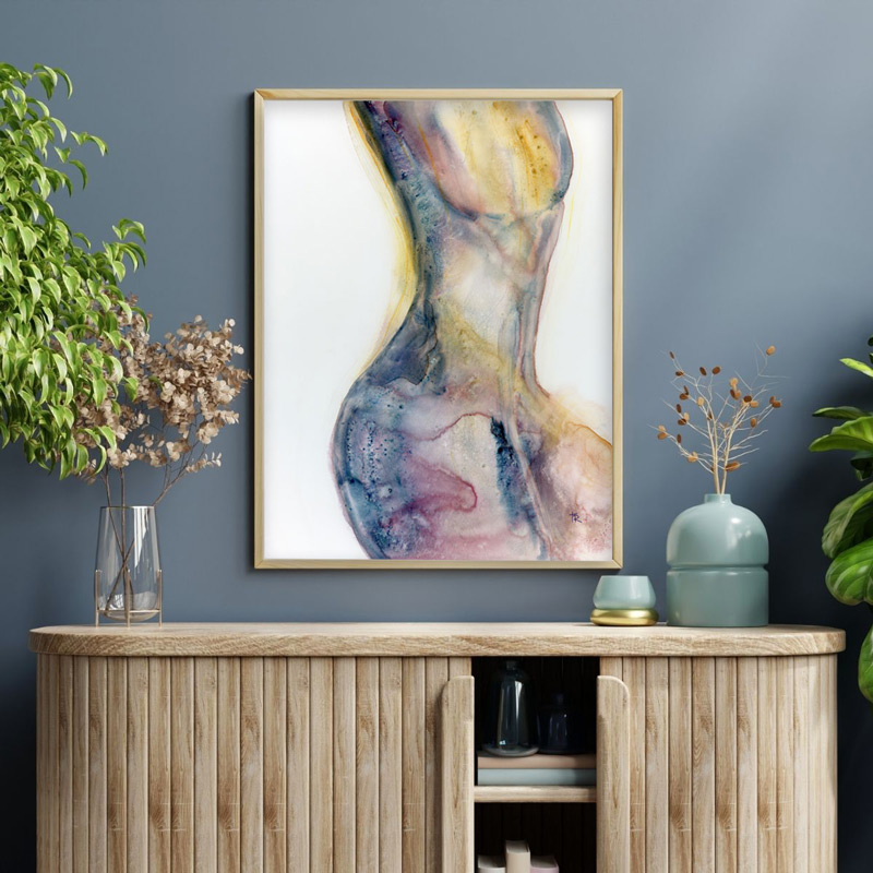 Original watercolor figure painting titled Feels Like a Woman by Tara Rochelle Art, shown framed on a blue wall with potted plants.
