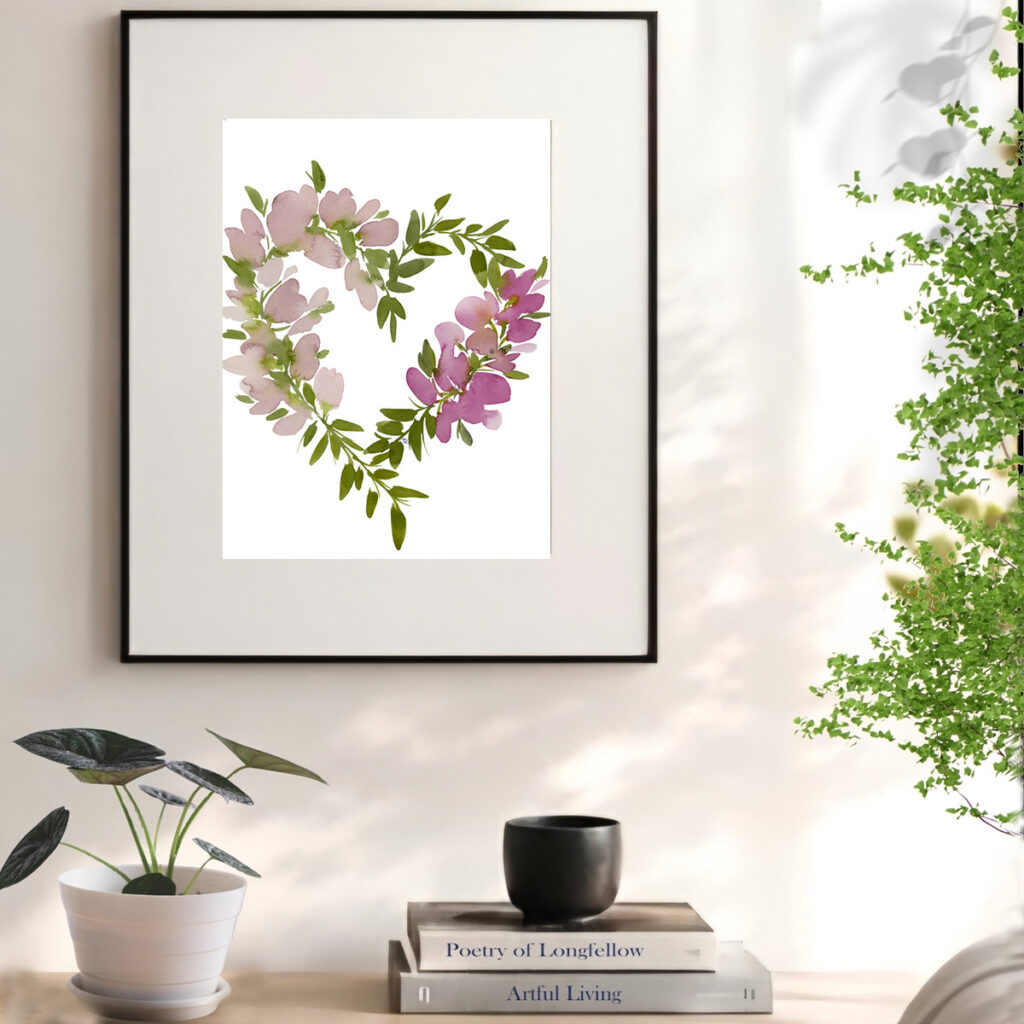 Framed watercolor floral art print styled in a bright reading nook with sunny window light.